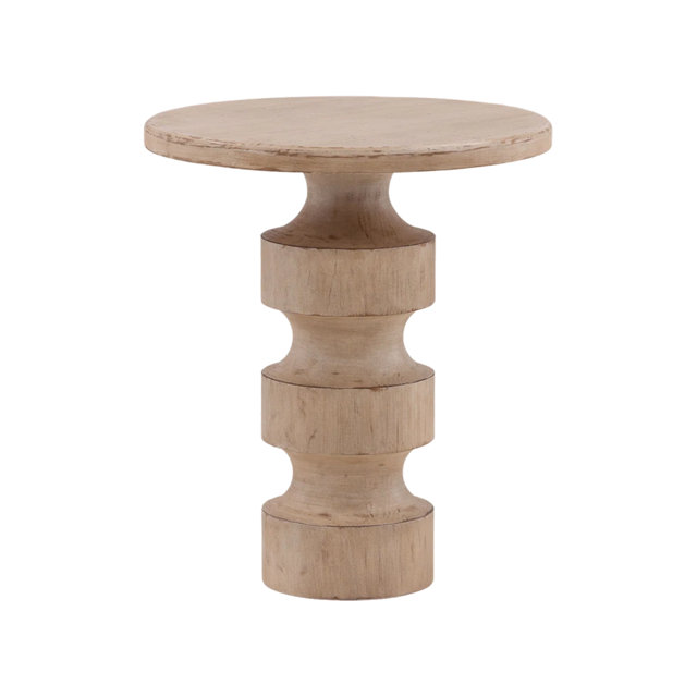 Round side table made of light wood with a distressed finish and a thick, tiered sculptural pedestal base.