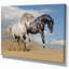 Chevaux blancs et noirs au galop dans le désert - reproduction de photo sur toile tendue-29495875
