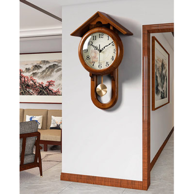 Vintage solid wood wall clock with a roof-shaped top and a metal pendulum