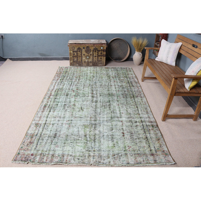 Tapis turc vintage vert avec un motif délavé unique pour une décoration intérieure élégante dans des tons pastel doux