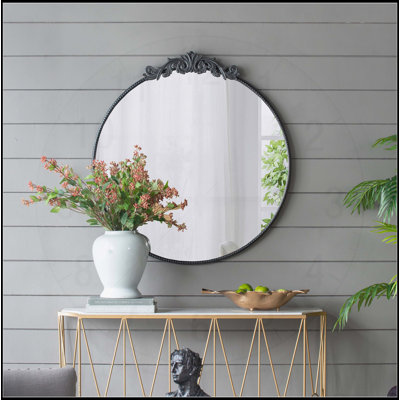 Élégant miroir rond mural avec cadre en métal, idéal pour la décoration de salle de bain et de salon.