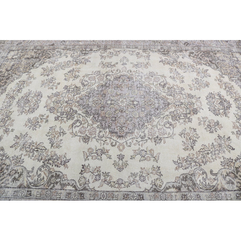 Un élégant tapis turc rétro à motif floral avec des tons neutres rehausse votre salon