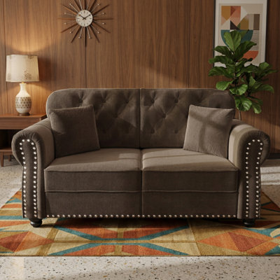 Fauteuil capitonné en velours avec accoudoirs roulés et garniture cloutée