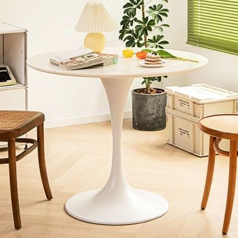 Table ronde blanche avec piètement en acier massif pour un usage quotidien dans un salon moderne et stable