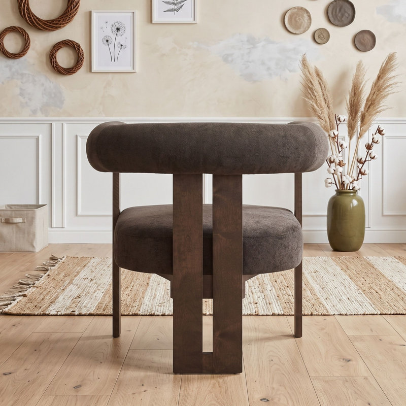 Fauteuil d'appoint moderne en bois rembourré, avec accoudoirs arrondis, dossier incurvé et piètement à trois pieds.