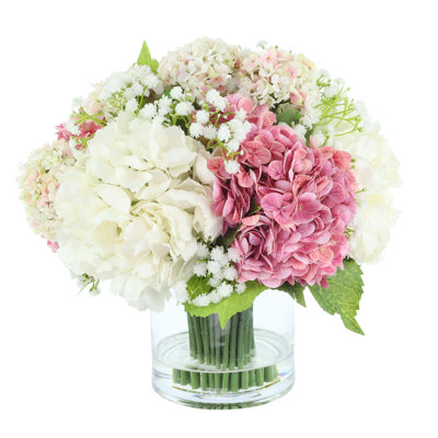 Hortensias et viburnum disposés dans un vase en verre
