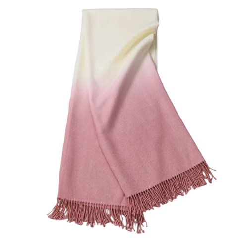 Throw blanket with a pink gradient and tassels.