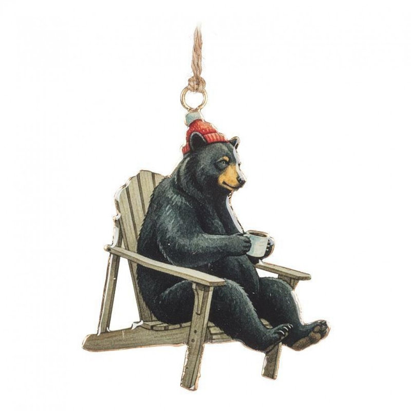 Ours portant une tuque dans une chaise Muskoka tenant un ornement de café