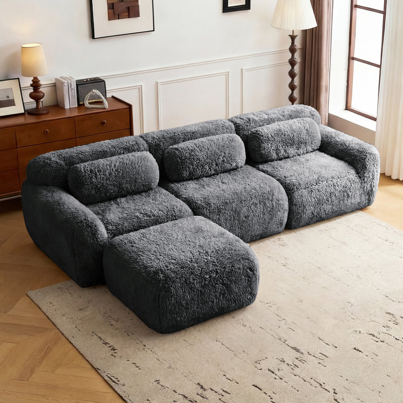 Canapé modulaire en L en peluche avec zones compressées, rembourré de mousse haute densité 32D, comprenant un repose-pieds amovible.
