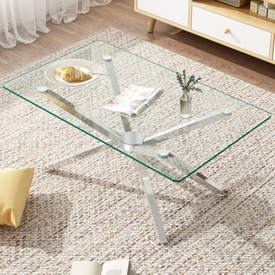 Table basse moderne en verre trempé avec pieds argentés et salon élégant
