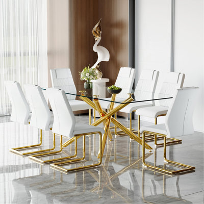 Ensemble de table et de chaises. Ensemble de table de salle à manger moderne en verre trempé transparent luxueux avec 8 chaises. Pieds de table en métal doré à fourche simple.