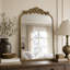 Miroir mural baroque antique doré en arc de cercle avec crête florale ornée-130491466
