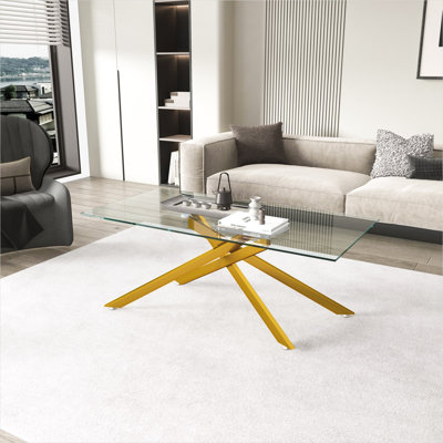 Modern rectangular glass coffee table with clear tempered top and metallic gold legs for living room display