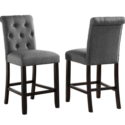 2 tabourets de comptoir gris. Bois massif avec sièges et dossiers élégants. Rembourré pour un confort maximal. Pieds en bois au fini foncé. Chaises à haut dossier délicatement courbées. L 23 po x P 19 po x H 40,52 po. Siège: l 19 po