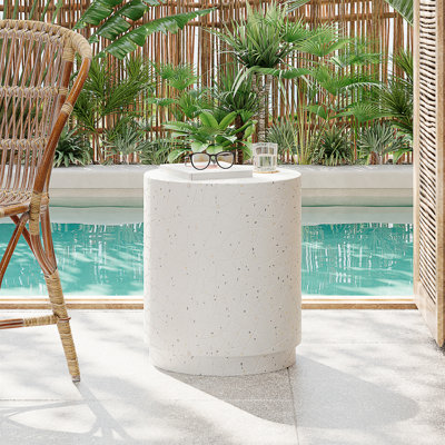 Table de bout d'extérieur extérieure en béton Terrazzo avec finition élégante mouchetée et silhouette cylindrique pour une utilisation polyvalente.