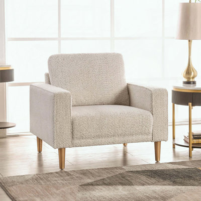 Fauteuil Boucle avec nuances métalliques, dossier coussiné et accoudoirs fins