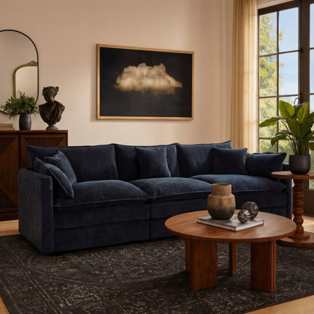 Living room with a navy blue sofa, wooden coffee table, and black patterned rug.