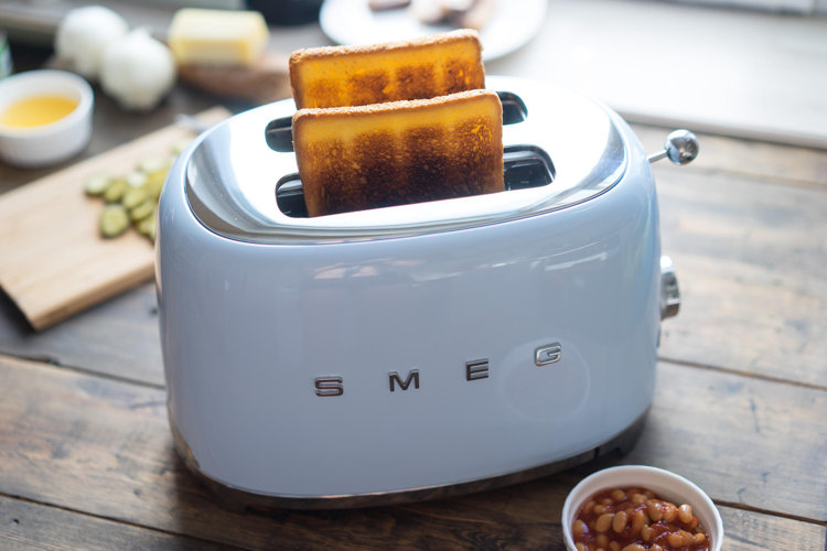 closeup of a retro style Smeg toaster with two pieces of bread in it
