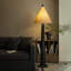 Une lampe sur pied en bois massif à côté du canapé dans le salon créatif