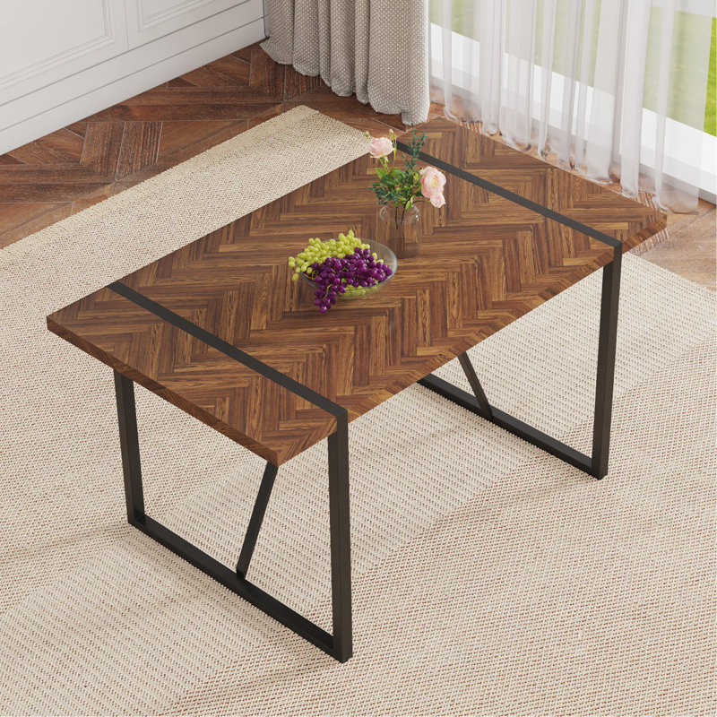 Une table de salle à manger rectangulaire rétro minimaliste avec un dessus spécialement texturé et des pieds en métal noir. Plateau de table contemporain en bois aggloméré minimaliste
