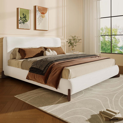 Élégant lit tapissier avec pieds en bois massif brun foncé, centre de chambre luxueux et confortable
