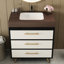 Meuble-lavabo Mid-Century moderne avec lavabo en céramique et plateau en pierre frittée. Il comporte un tiroir inclinable à fermeture en douceur pour un rangement efficace. Les pieds en acier thermolaqué ajoutent de la stabilité