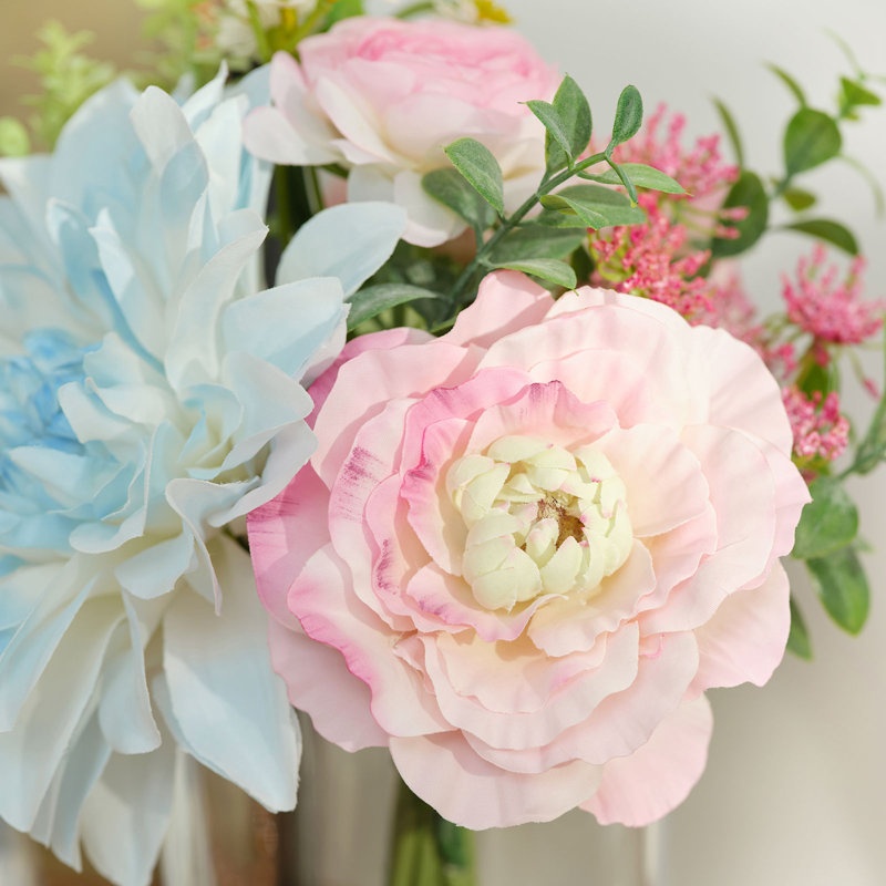 Faux dahlia, eucalyptus et renoncule dans un vase