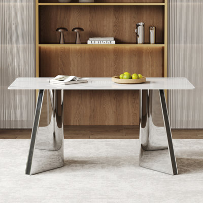 Table de salle à manger luxueuse 63 po x 31,5 po x 30 po en pierre frittée avec pieds papillon en acier inoxydable argentés. Le plateau de table est conçu pour résister aux égratignures et à la chaleur