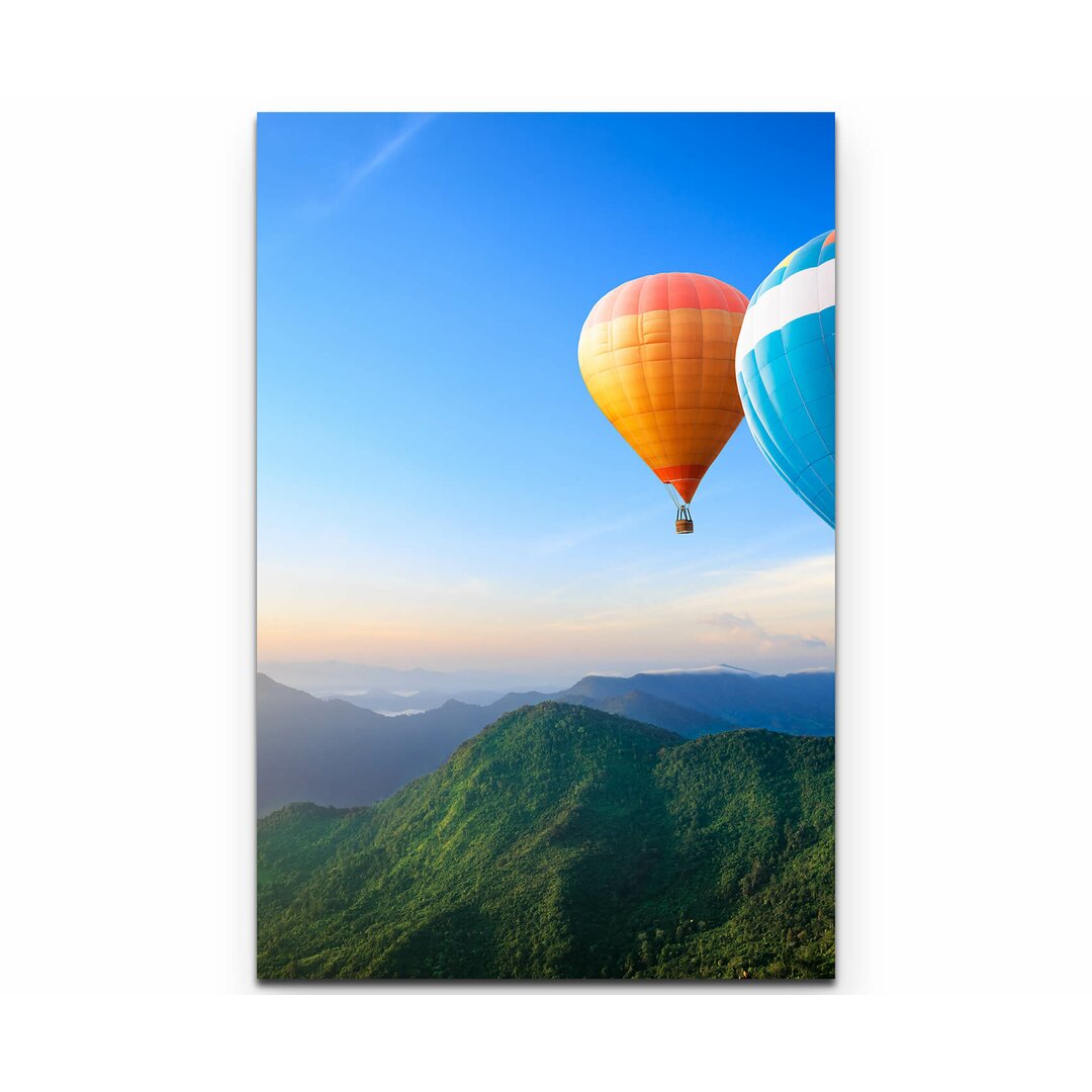 Leinwandbild Bunte Heißluftballons über Bergkette