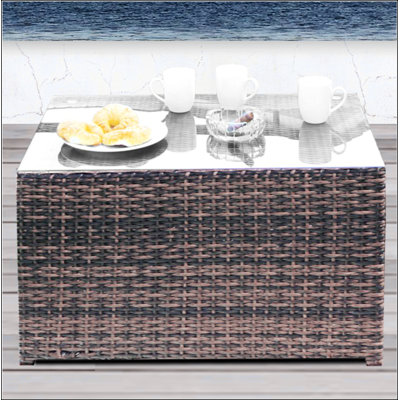 Table basse à plateau rectangulaire en verre entièrement assemblée avec base en osier / rotin, parfaite pour les espaces de vie modernes et confortables.