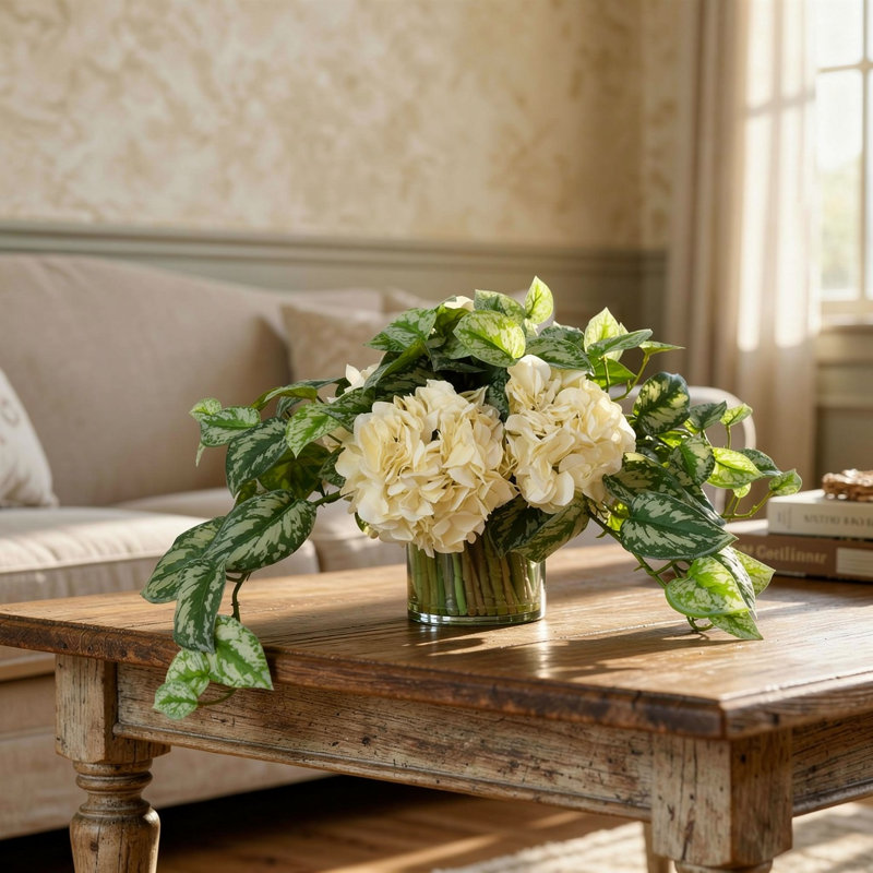 Arrangement d'hortensias et de scindapsus dans un vase en verre