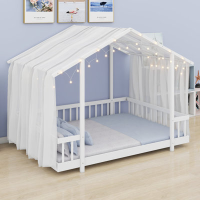 Un lit plateforme avec un baldaquin en forme de maison et des lumières scintillantes ajoute une touche de conte de fées à la chambre d'un enfant.
