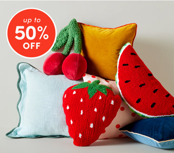 Bedding accents up to 50% off featuring colorful throw pillows including strawberry, watermelon and cherry shapes