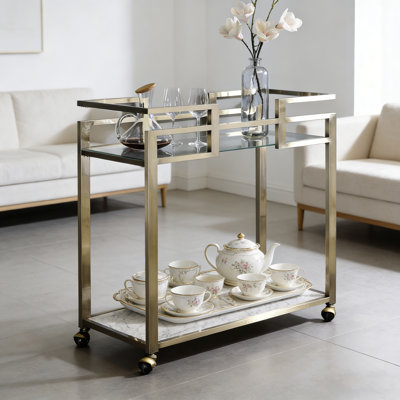 Chariot de service Neilo en verre transparent et plateau en faux marbre avec cadre en fil de laiton pour une utilisation multifonctionnelle élégante.