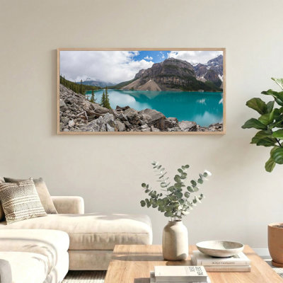 Tableau sur toile représentant un lac de montagne turquoise avec rivage rocheux et pins