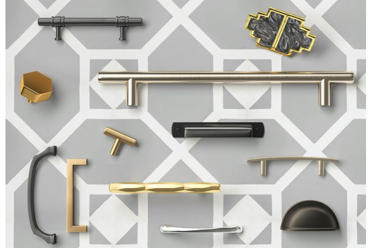 arrangement of different drawer pulls and cabinet knobs in silver, gold, and matte black metal against a gray geometric background