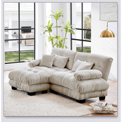 Luxueux canapé en chenille pour le salon avec plusieurs coussins et repose-pieds convertible, pour plus de confort et de style.