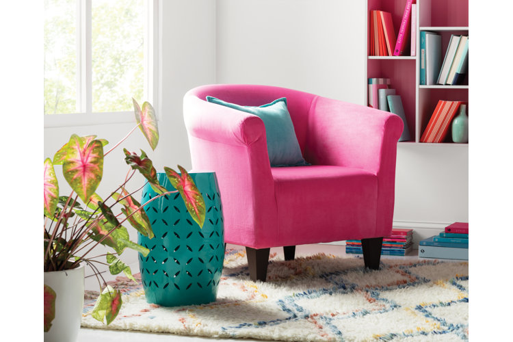 hot pink accent chair next to bookshelf