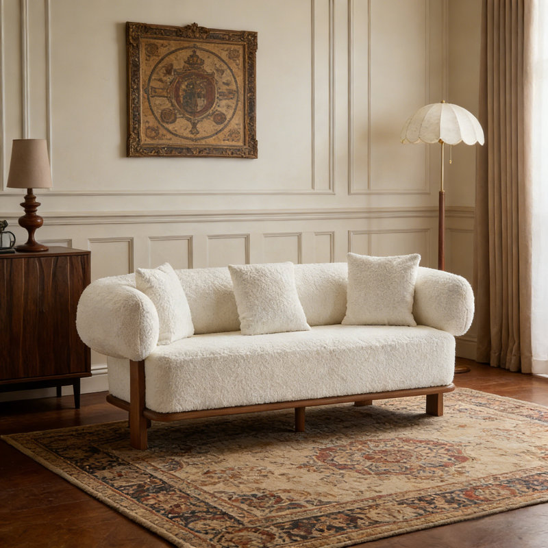 Canapé à accoudoirs arrondis courbés de couleur beige avec design ergonomique et siège très profond pour un confort inégalé et une esthétique moderne