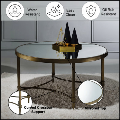 Table basse Aditya en laiton antique et miroir, avec plateau réfléchissant et design incurvé élégant, idéale pour les intérieurs modernes et traditionnels.