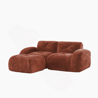 Repose-pieds en velours désossé en forme de L avec un design capitonné, une éponge haute densité, une forme ergonomique et une base antidérapante pour des agencements de salon flexibles.
