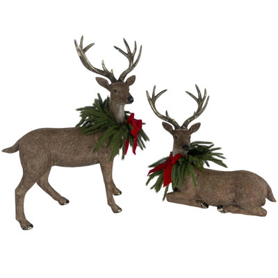 Ensemble de 2 figurines de renne de Noël rustique en résine durable avec des colliers en faux pin et des arcs rouges, des statues de cerfs debout et couchés pour une présentation des Fêtes à l'intérieur ou à l'extérieur