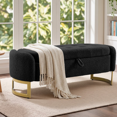 Banc de rangement capitonné Teddy avec pieds en fer courbés, structure en bois massif et plateau relevable à languette.