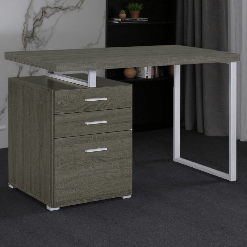 Bureau d'ordinateur moderne à 3 tiroirs réversible avec structure en métal et finition gris vieilli, idéal pour les espaces de travail flexibles.