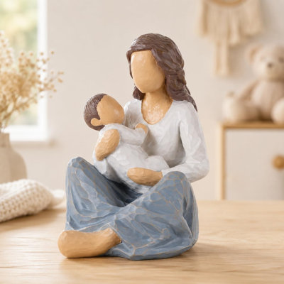 Sculpture mère en résine assise tenant un enfant
