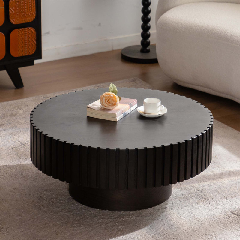 Table basse ronde en bois sculpté à la main avec un piètement robuste pour une décoration de salon élégante