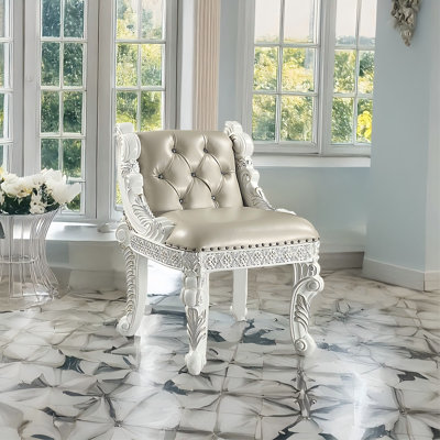 Chaise de coiffeuse de luxe européenne Vanaheim 61 cm – Bois massif blanc antique orné de motifs floraux sculptés, dossier capitonné à boutons en losange, accoudoirs incurvés ornés de clous décoratifs – Siège de coiffeuse classique royal