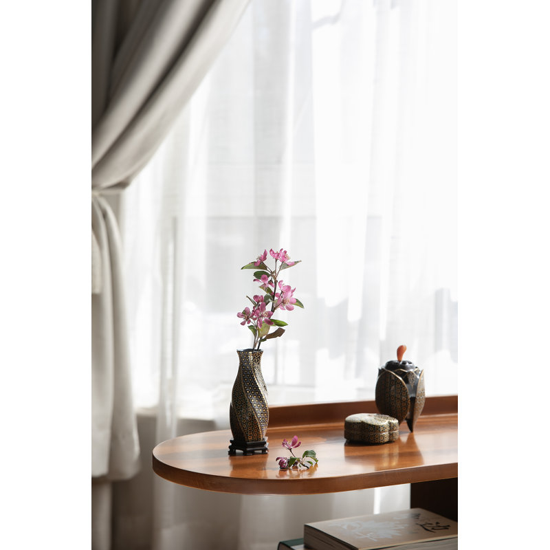 Fleurs tourbillonnantes sur une bouteille d'encens noire