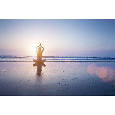 Woman Practicing Yoga On The Beach