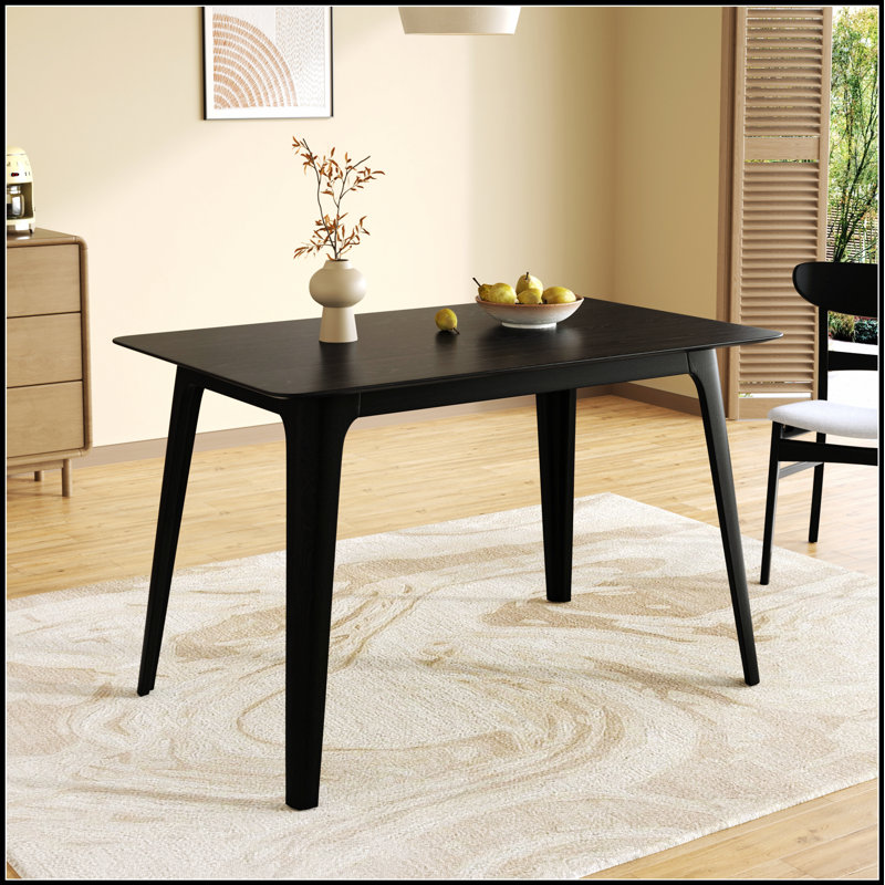 Table de salle à manger de style Mid-Century moderne avec pieds en bois massif et finition noire élégante pour les espaces compacts